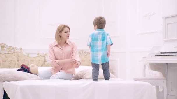 Мати і син грають у ліжку. Батьківство і виховання, щасливе дитинство . — стокове відео