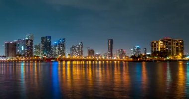 Miami Panorama zaman aşımı. Miami plaj şehrinde gece gökyüzü zamanı. Okyanus suyu olan şehir manzarası. MacArthur şehir merkezinde, Causeway şehrinde..