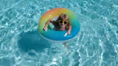 Havuzda oynayan bir çocuk. Tatil ve çocuklarla seyahat. Çocuklar yazın dışarıda oynarlar. Yüzüklü çocuk.