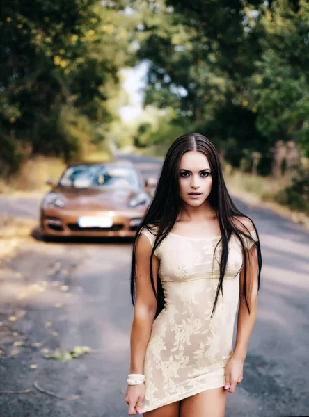 Outdoor portrait of young elegant woman walking in street. Young fashion model, urban style. Beautiful young woman on car background. — Fotografia de Stock