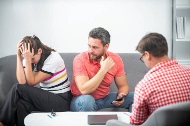 Aile içi sorunları sosyal hizmetler görevlisi ya da aile psikologu ile tartışan bir çift. Aile içi anlaşmazlıklar, evlilik krizi.