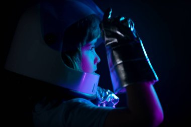 Kapalı çocuk portresi siyah, macera hayalinde izole edilmiş. Miğferli ve koruyucu uzay giysili küçük astronot portresi.