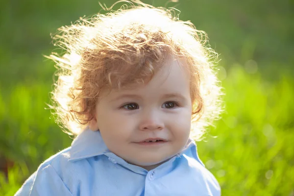 Cute little baby on the meadow field. Toddler child walking outdoor, family vacations. Baby face closeup. Funny little child close up portrait. Blonde kid, smiling emotion face. — Foto Stock