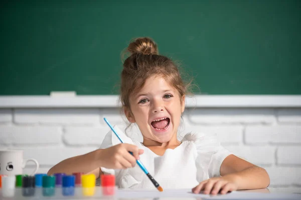 Painting school lesson, drawing art. Portrait of adorable little girl smiling happily while enjoying art and craft lesson in school. Funny kids emotions. — Fotografia de Stock