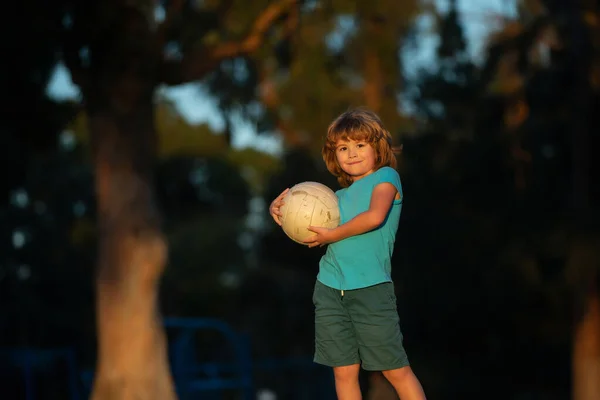 Excited child boy kicking ball in the grass outdoors. Soccer kids, children play football. Active ball games. — Zdjęcie stockowe