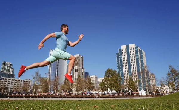 Gesunder Mann läuft und joggt in voller Länge im Freien. Männliches Model in Sportbekleidung beim Outdoor-Training im Stadtpark. Stadtsportkonzept. — Stockfoto