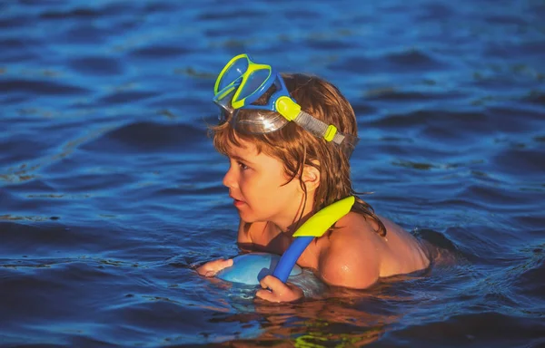 In den Sommerferien schwimmen Kinder am Strand. Kind in der Natur mit schönem Meer. Glücklicher Junge schwimmt im Wasser. — Stockfoto