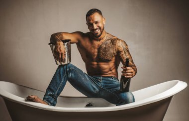 Seksi gülümseyen adam banyoda küvete oturur, erkekler şampanya ile tatil yapar. Noel 'i ya da doğum gününü kutlamak için. Özel seks partisi.