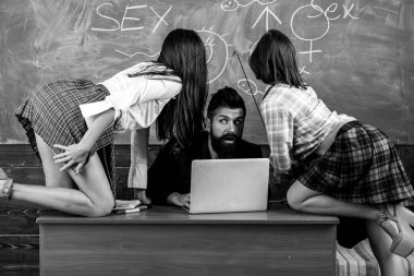 Seksoloji öğretmen iki seksi kız öğrenci görünüyor. Erotik eğitim ve kara tahta üzerinde seks sembolleri.