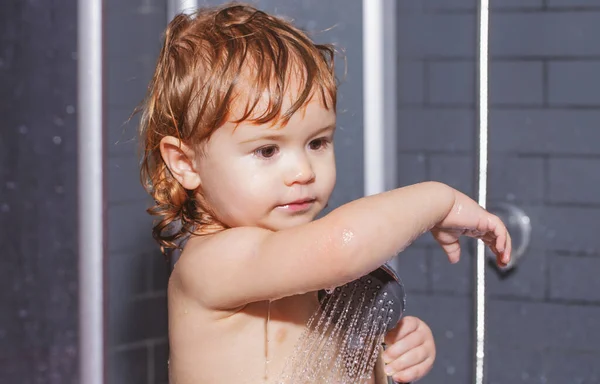 Nettes Kind wäscht Körper in Badewanne. Lustiges fröhliches Baby badet in Badewanne mit Wasser und Schaum. Kinderhygiene. — Stockfoto