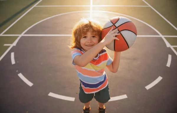 バスケットボールでバスケットボールをしている子供の男の子. — ストック写真