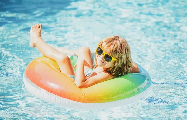 Vacaciones de verano. Fin de semana de verano. Chico divertido en piscina de natación en círculo de goma inflable en aquapark. — Foto de Stock