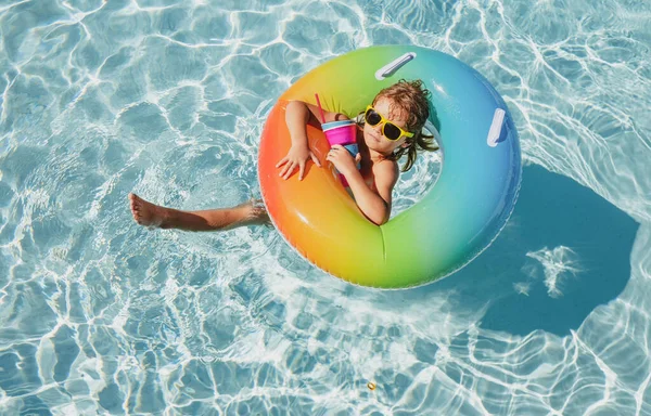 Petit garçon insouciant le week-end d'été. Activités estivales ou aventure à aquapark. Drôle garçon heureux enfant dans la piscine sur anneau en caoutchouc gonflable cercle. — Photo