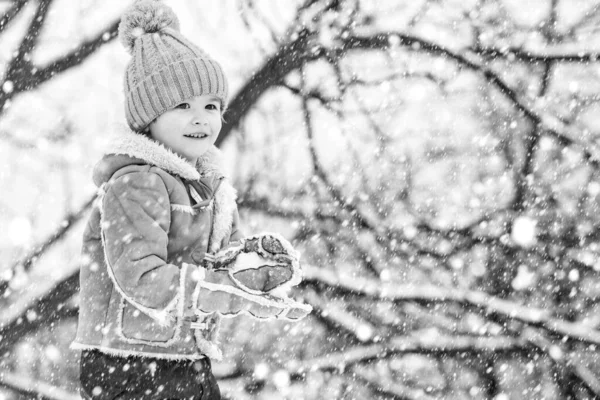 Christmas kids in snow. Theme Christmas holidays New Year. Winter snow and child game. Happy winter time for kid. Joyful little boy child Having Fun in Winter Park. — Stock Photo, Image