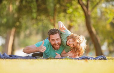 Mutlu baba ve oğul güneşli bir parkta tatilin tadını çıkarıyorlar..