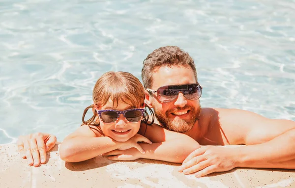 父亲和儿子在游泳池里暑假的概念。快乐的家人在游泳池里。泳池派对和爸爸一起的孩子父亲节. — 图库照片