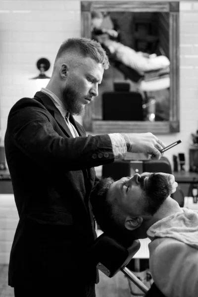 Barbudo visitando estilista en peluquería. Barbudo cortado por peluquero en la peluquería. Peluquero y estilista . — Foto de Stock