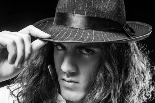 Young handsome man emotional pose with hat. Portrait of handsome young serious confident young guy with long hair in hat. Man with confident face and brutal style. Barbershop advertising. — Stok Foto
