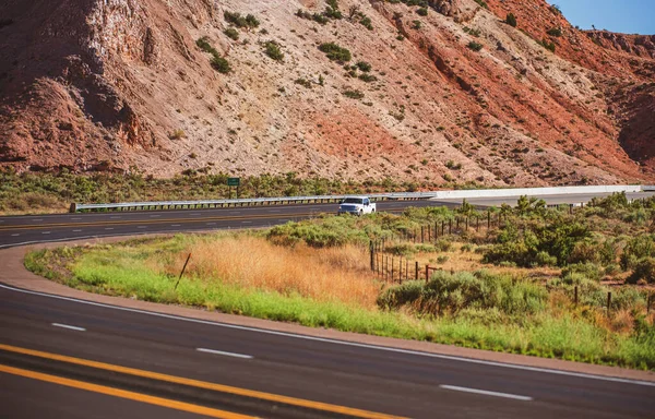 Pohled na dálniční silnici protékající neúrodnou scenérií amerického jihozápadu s extrémním horkým oparem v létě. — Stock fotografie