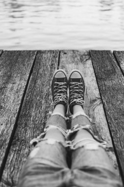 Bacaklar bir kampı için bir dinlenme göl kenarında otururken ücretsiz bir gezgin. Özgürlük zaman özgürlük savaşçısı. Seyahat ve Özgürlük kavramı