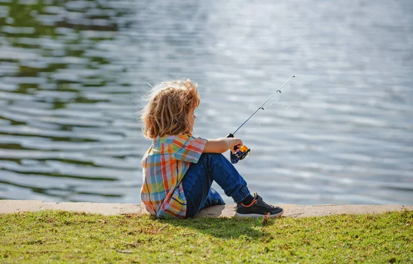 Un ragazzo pescatore. Ragazzo con la trottola al fiume. Ritratto di ragazzo eccitato pesca. Ragazzo al molo con asta. Concetto di pesca. — Foto Stock