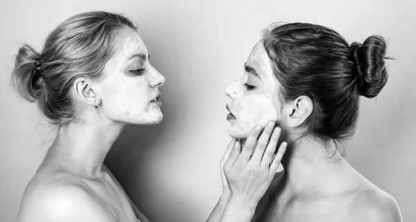 Filles tendres naturelles en bonne santé font des procédures de spa de beauté avec masque de boue d'argile au visage. Bonne humeur drôle. Concept santé et bien-être. Les femmes avec les épaules nues font des procédures spa. — Photo