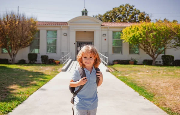 O miúdo sorridente feliz vai para a escola. Menino com bolsa vai para a escola primária. Escola primária. Aluno vai estudar com mochila. Ir para a escola. — Fotografia de Stock