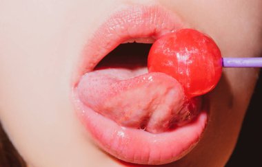 Dilini yalıyor. Dudakları şekerli, seksi tatlı rüyalar. Oral seks konsepti. Dişi ağız chupa chup yalıyor, lolipop emiyor..