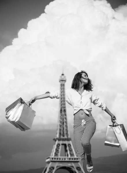 Shopping in Paris. Happy woman after shopping rejoices purchases. Fashion woman near Eiffel Tower in France. Trendy girl with shopping bags. Fashion and vogue concept. — Stock Photo, Image