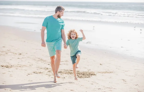 Pai e filho correndo na praia de verão. Pai e criança brincando ao ar livre. — Fotografia de Stock