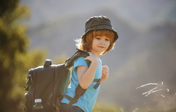 Criança com mochila caminhando em montanhas cênicas. Criança turista local vai em uma caminhada local. — Fotografia de Stock