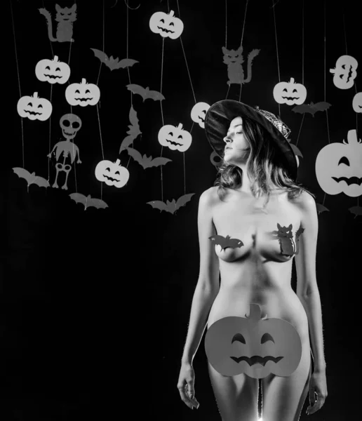 The Most Popular Candy for Halloween. Nude woman witch with halloween hat and pumpkin. Womens clothing store celebrates Halloween. Sexy Horror background.Woman shows a beautiful ass or butt. — Stock Fotó