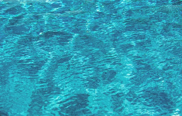 Fondo de agua azul en la piscina con reflejo solar, ondulación de la ola de agua en la piscina. Fondo de agua clara. —  Fotos de Stock