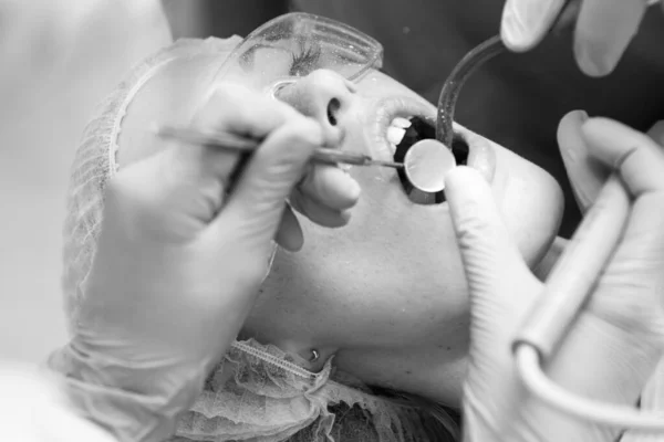 Belle jeune femme avec des dents saines sur fond blanc. Portrait en gros plan d'une patiente en visite chez le dentiste pour le blanchiment des dents en clinique. Concept de soins dentaires . — Photo