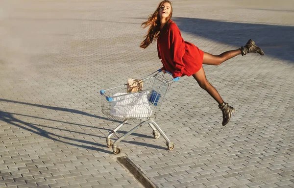 Chica de compras con carrito de compras. Concepto de comercialización. —  Fotos de Stock
