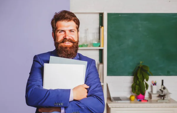 Χαμογελώντας καθηγητής δάσκαλος στέκεται μπροστά από μαυροπίνακα διδασκαλία μαθητή στην τάξη. Όμορφος δάσκαλος στην τάξη. — Φωτογραφία Αρχείου