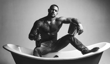 Stresli bir iş gününden sonra rahatlamanın en iyi yolu. Atheltic İspanyol adam dinlenmek için şampanya içiyor. Fit gövde dövme ile Güçlü latino adam dinlenmek ve banyo keyfini çıkarın. Stres giderici spa dinlenmek