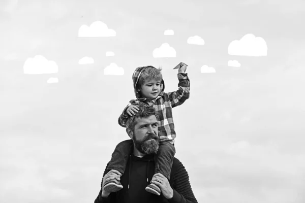 Padre e figlio giocano insieme. Padre e suo figlio bambino giocano all'aperto. L'infanzia. Libertà di sognare - Gioioso ragazzo che gioca con l'aereo di carta. — Foto Stock