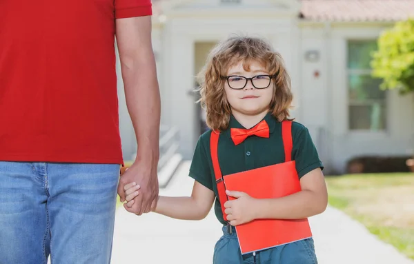 Školák chodí do školy s otcem. Den učitelů. Portrét šťastného šprta žáka držícího učitele za ruku. — Stock fotografie