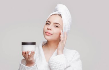 Temiz tenli güzel genç bir kadın kendi yüzüne dokunur. Yüz bakımı. Kozmetik, güzellik ve kaplıca.