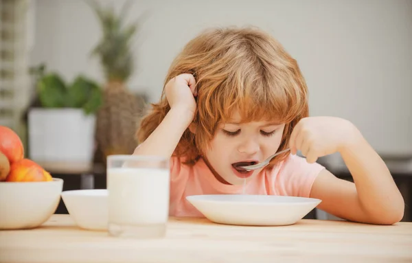 Een close-up gezicht van een kind dat biologisch voedsel eet, yoghurt, melk. Kind gezond eten. — Stockfoto