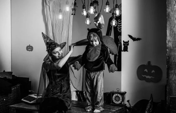 Mom and son play for all saints day in witchs costume at home. Mother and child boy playing together. 31 october. Magic hat. Best ideas for Halloween. Mother wearing as witch, son wearing as devil. — Stock Photo, Image