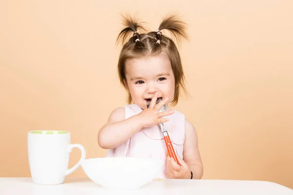 Bebés comiendo, comida saludable para un bebé. Niña sonriente con cuchara en el estudio, aislada. — Foto de Stock