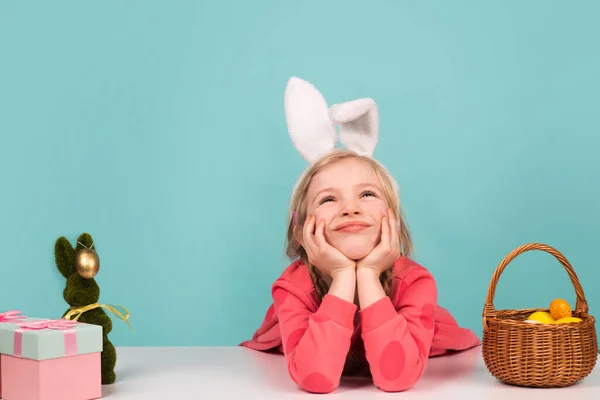 Easter child. Funny girl wearing bunny ears and having fun with Easter eggs. Funny bunny kids, copy space. — стоковое фото