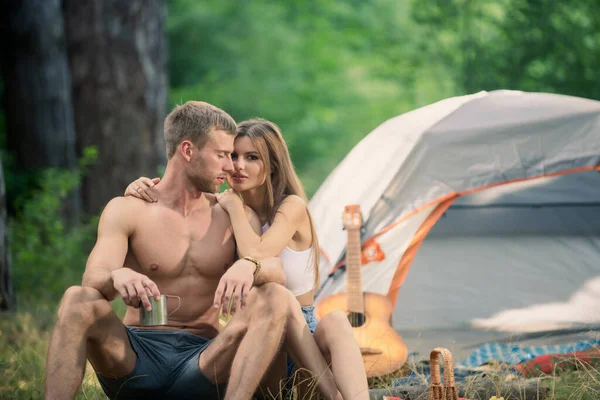 Loving young coupl hug near camp tent. Camping couple in love. Couples of lovers tourists relax on nature. Camping trip with lovers. Picnic for friends tourists. — Stockfoto