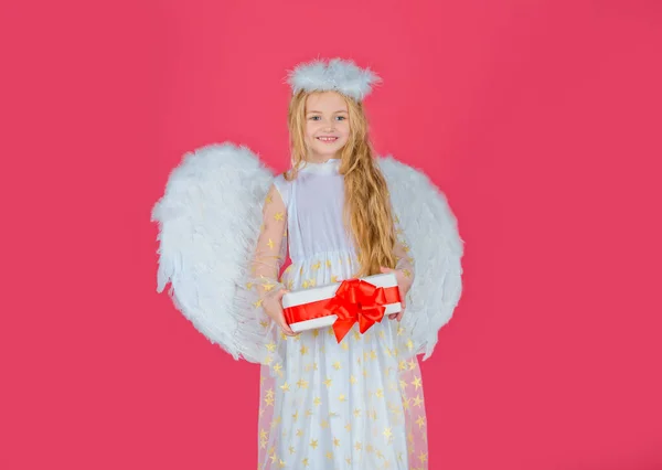 Child angel little girl with present gift, studio portrait. Girl prince greeting card. Little angel with white wings holds gift. Playful angelic little girl. Valentines day. — стокове фото