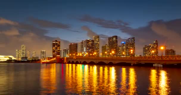 Miami panorama time lapse. Time lapse of sunset on cityscape sky and clouds moving with water ripple reflection. Night sky timelapse on Miami beach city. Cityscape with ocean water. — стокове відео