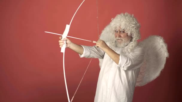 Valentin with bow arrow ready to shoot. Funny bearded man with feathers wings of Cupid Valentines Day. — Stockvideo