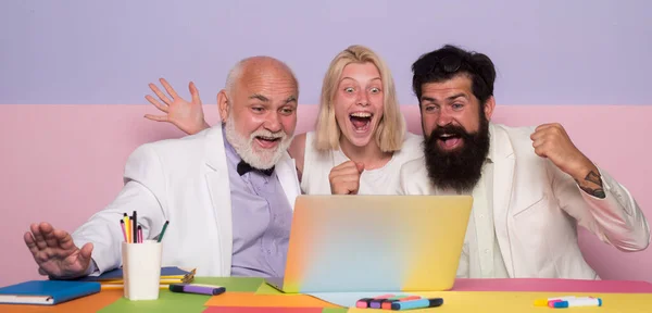 Successful entrepreneurs and business people. Funny excited group of businesspeople working on a laptop at a table in an office. — Stockfoto