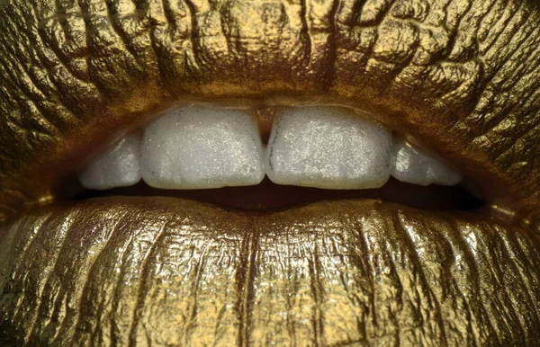 Golden lips macro close up. Lip icon with golden glitter effect. Sensual mouth. Symbol of kiss from golden lipstick. Glamour luxury gold mouth.